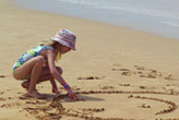child playing in the sand at Maui Ulua Beach